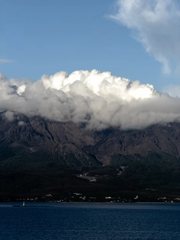 Clouds resting on mountains by the sea